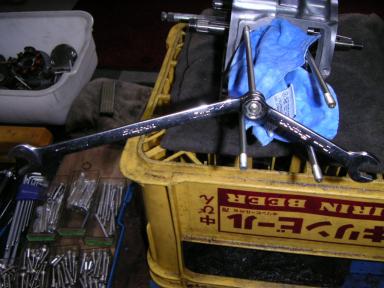 瓶ビールケースの上のクランクケースと工具